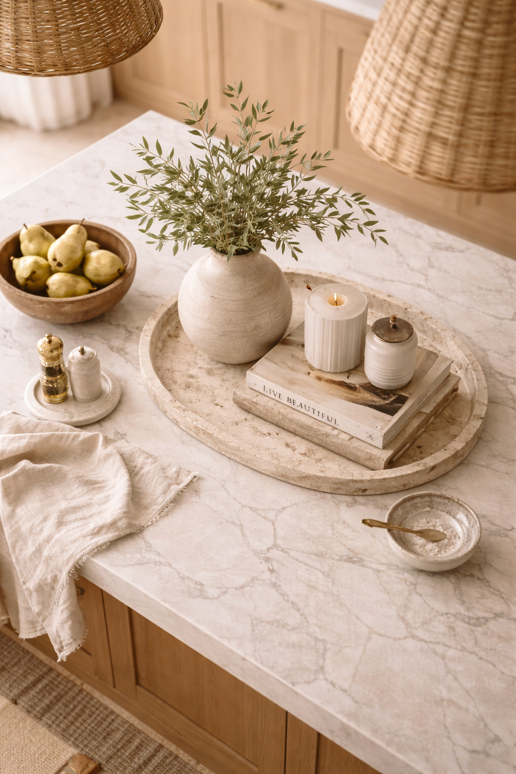overhead view of designer kitchen island styling formula with balanced decor placement, books, bowl, and greenery